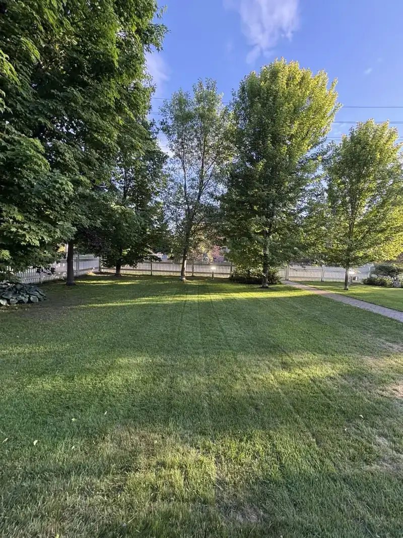 Manicured front lawn beside a white picket fence in North Bay