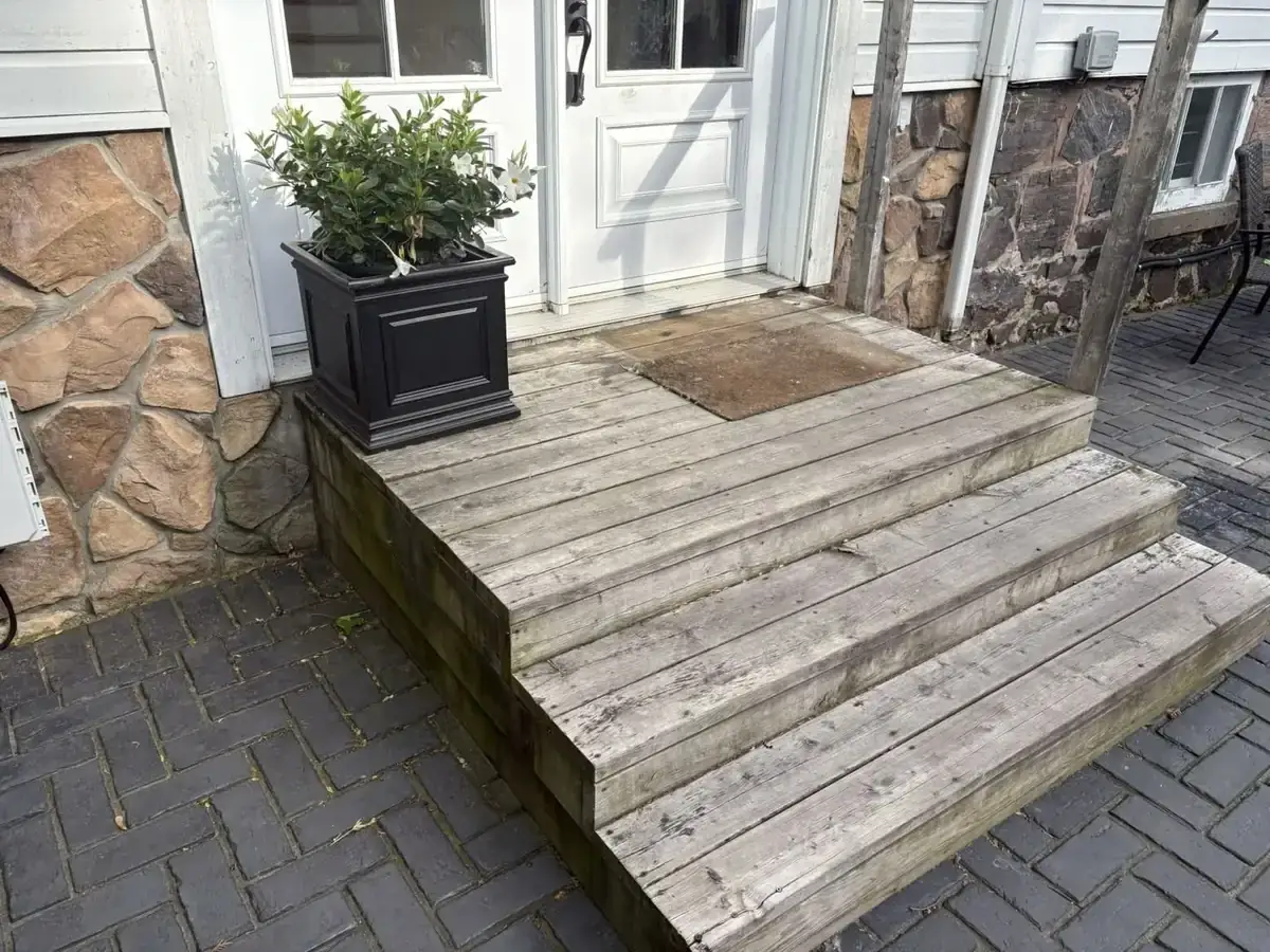 Front porch and wooden steps before pressure washing — weathered, gray, moss-stained boards