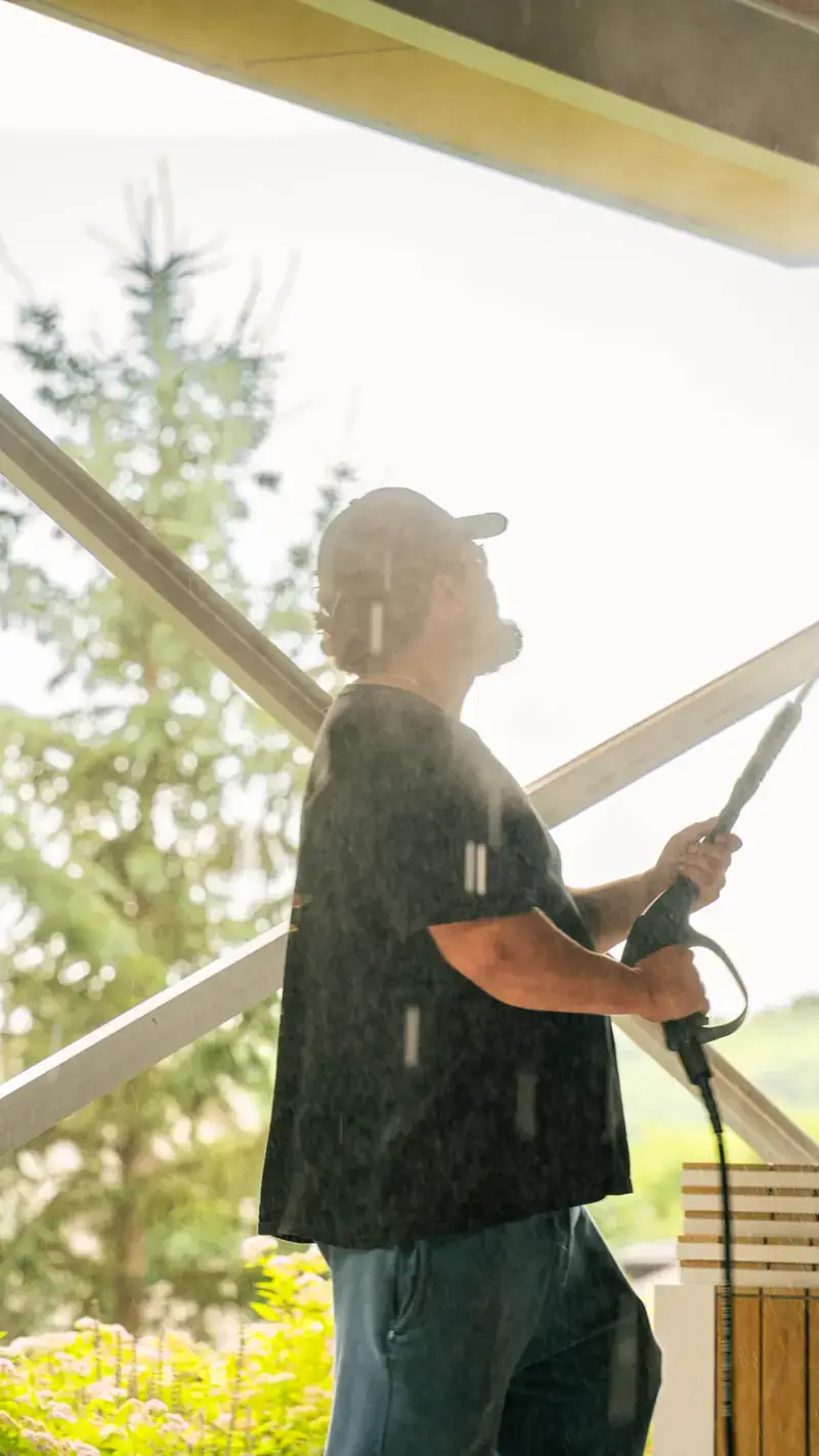 Nipissing Exteriors technician pressure washing exterior surfaces on a North Bay home